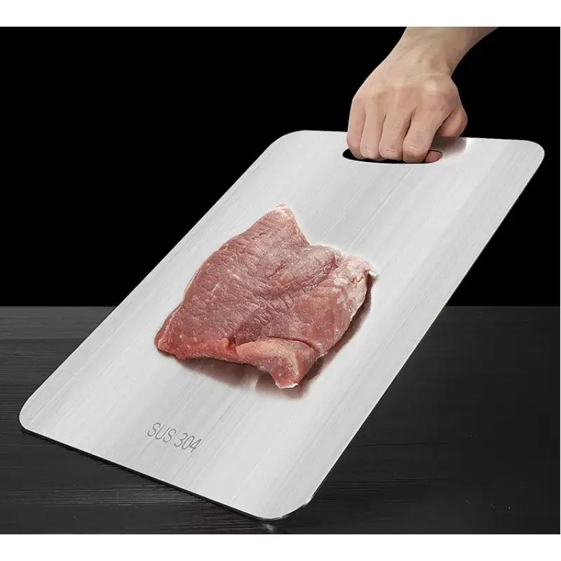 Et skærebart der har en steak læggende oven, hvor der er en hånd der holder og holder skærebrættet oven på